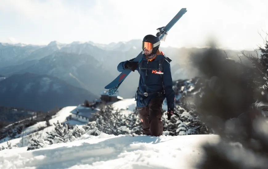 Skifahrer Portrait mit Ski am Rücken.